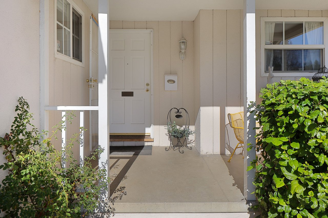 Covered front entry of Lake Balboa home with white door, decorative planter, and light staging details