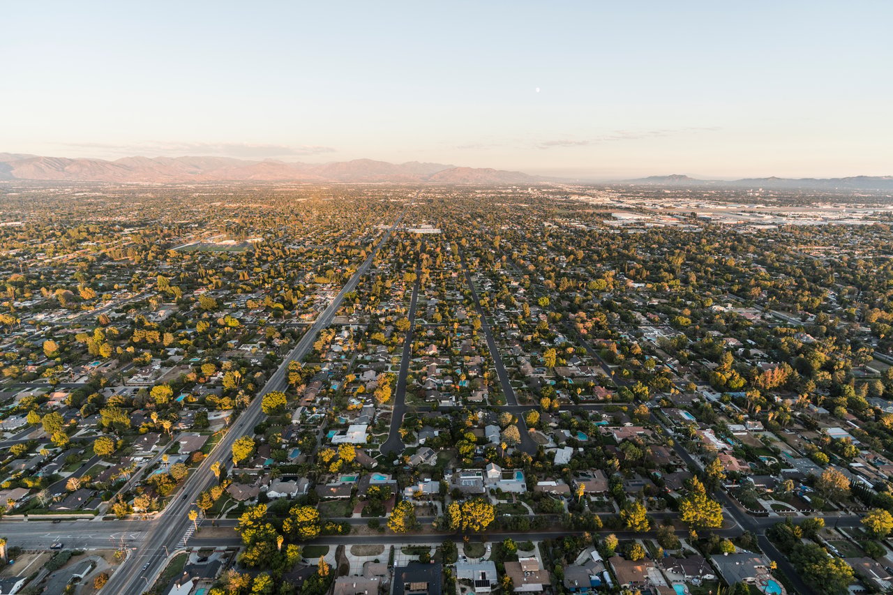 Aerial view of Northridge homes and tree-lined streets, with mountains on the horizon.