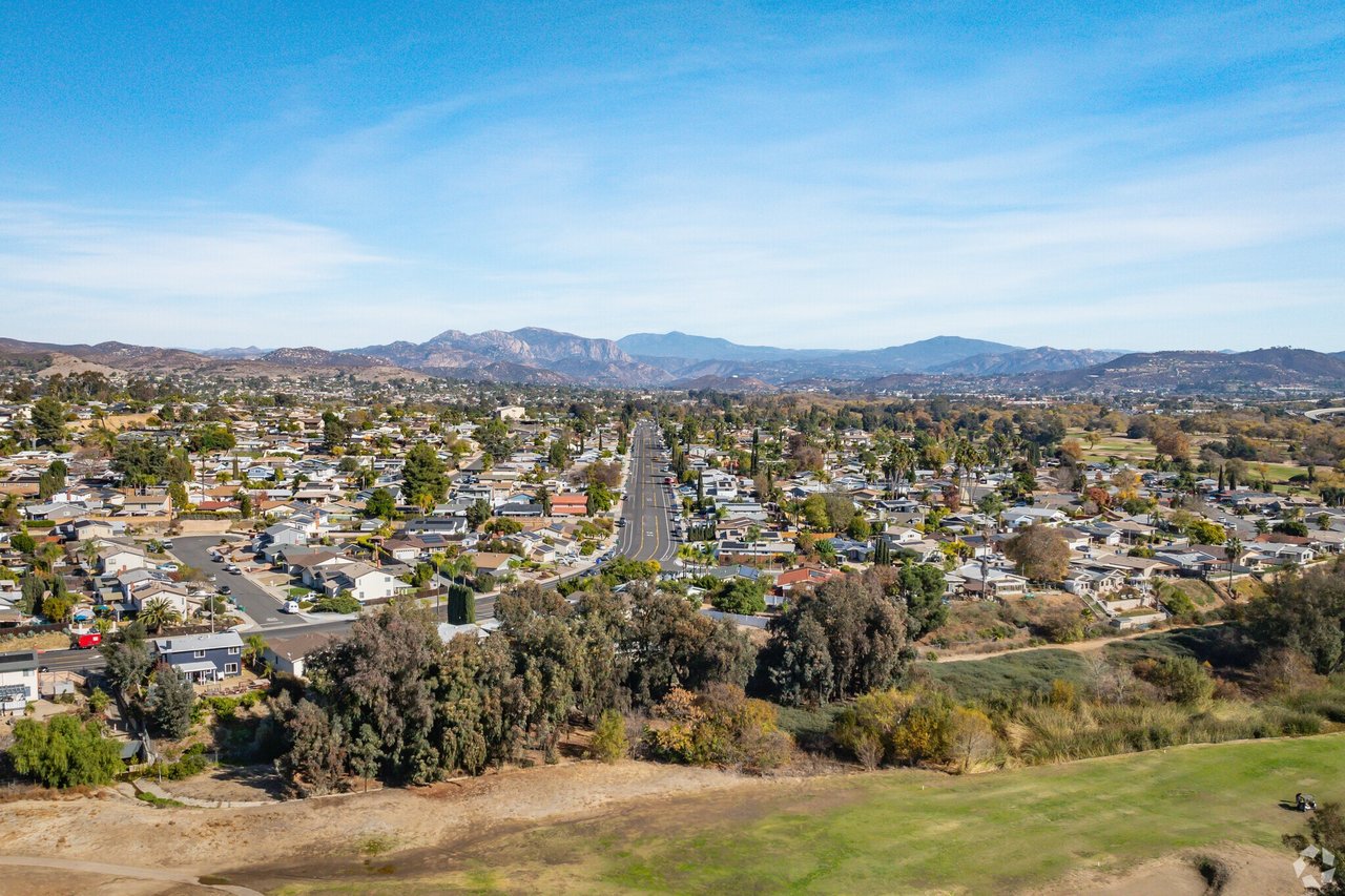 Aerial view of residential streets and houses in Santee, California, with surrounding hills and mountains in the background