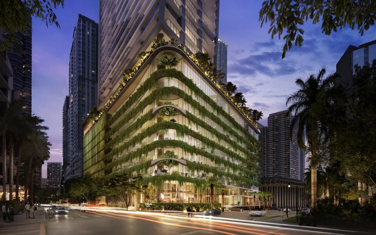 ORA by Tua Casa tower with lush planted balconies at dusk on a city street.