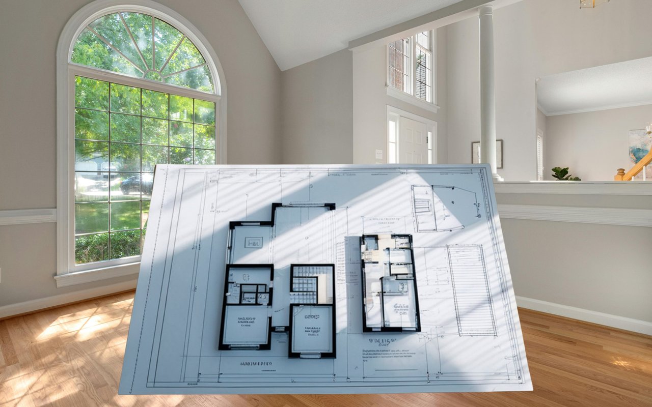 House floor plan displayed in a sunlit, empty room with an arched window.