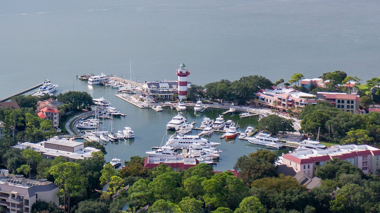 Hilton Head Island marina with yachts and a red-and-white striped lighthouse