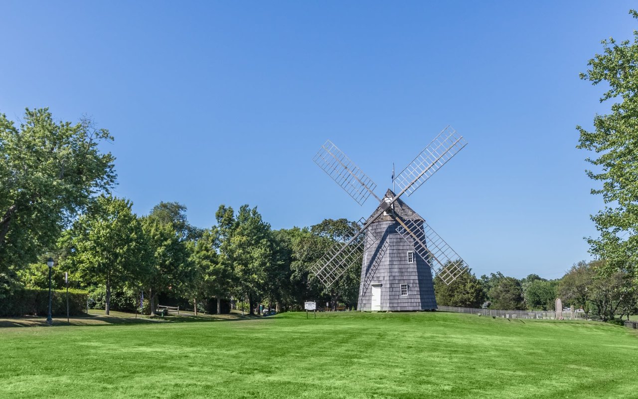 A windmill sitting in the middle of a field