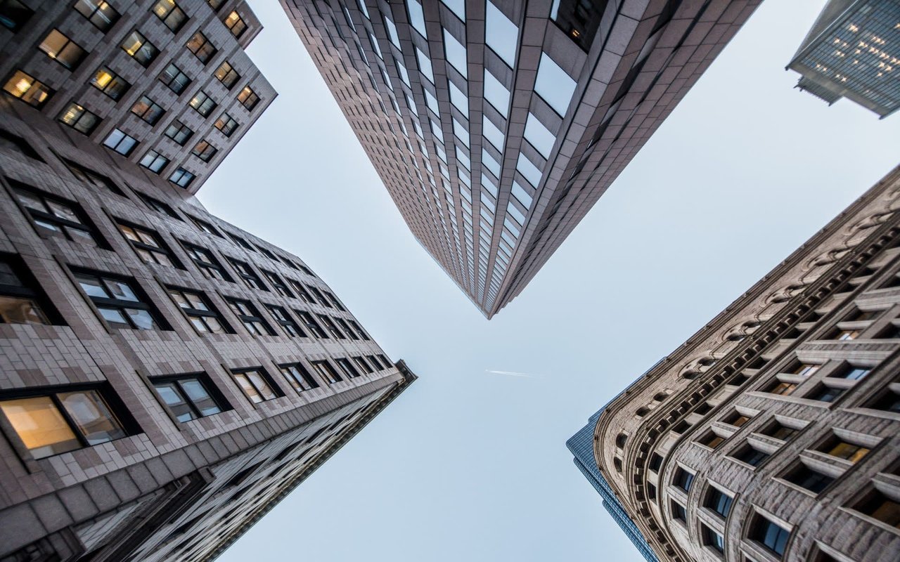 A serene cityscape with towering commercial skyscrapers and a blue sky.