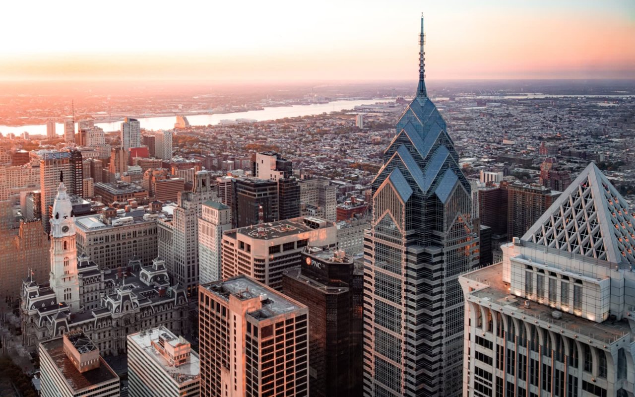 Aerial view of a city skyline at sunset with a river.