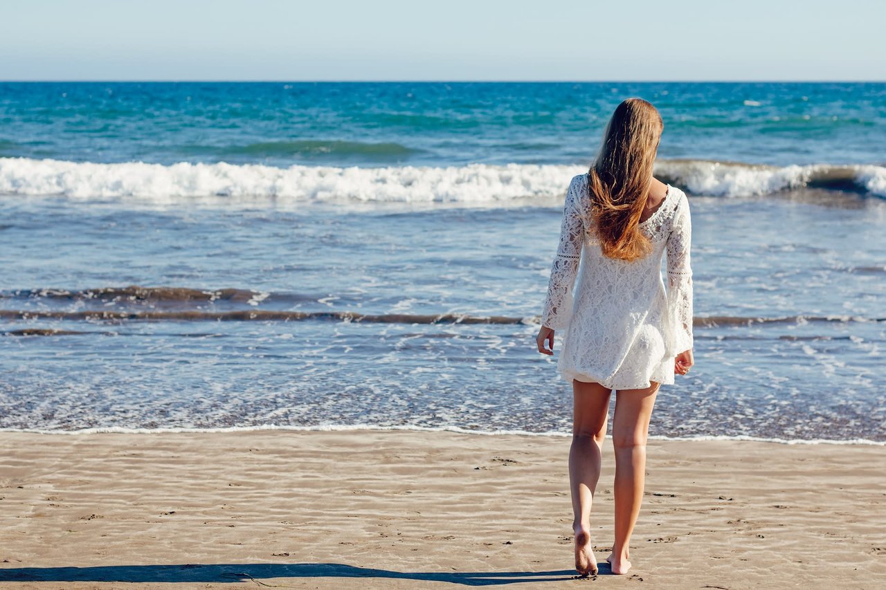 a girl walking towards the sea