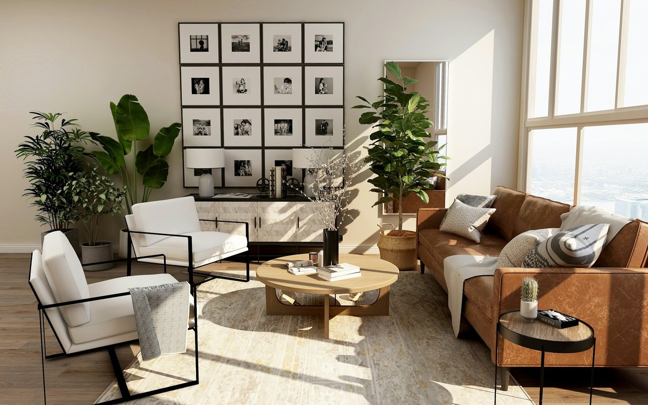 Bright living room with a brown leather sofa, white chairs, and large sunlit windows overlooking the city.