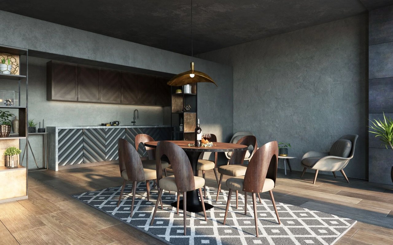 Modern dining area with a round wood table, upholstered chairs, and dark kitchen cabinetry.