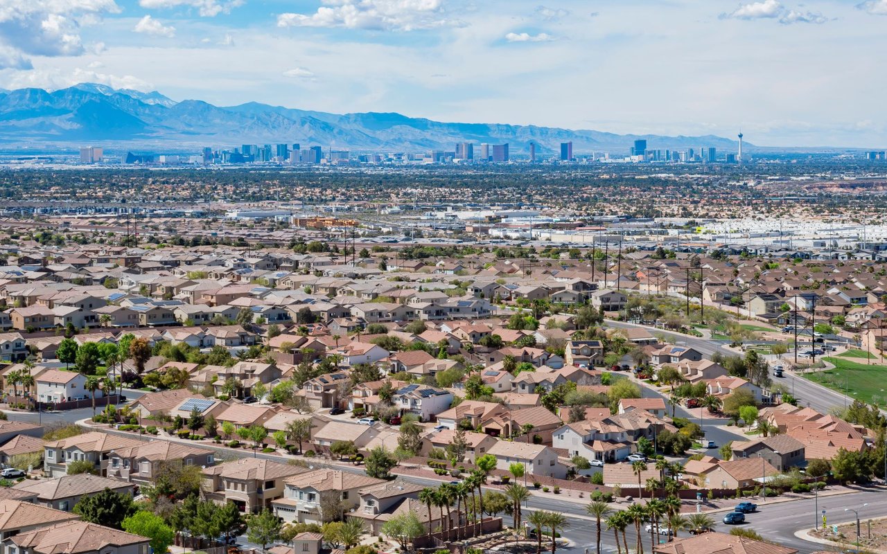 Desert homes in the foreground with the Las Vegas skyline and mountains in the distance.