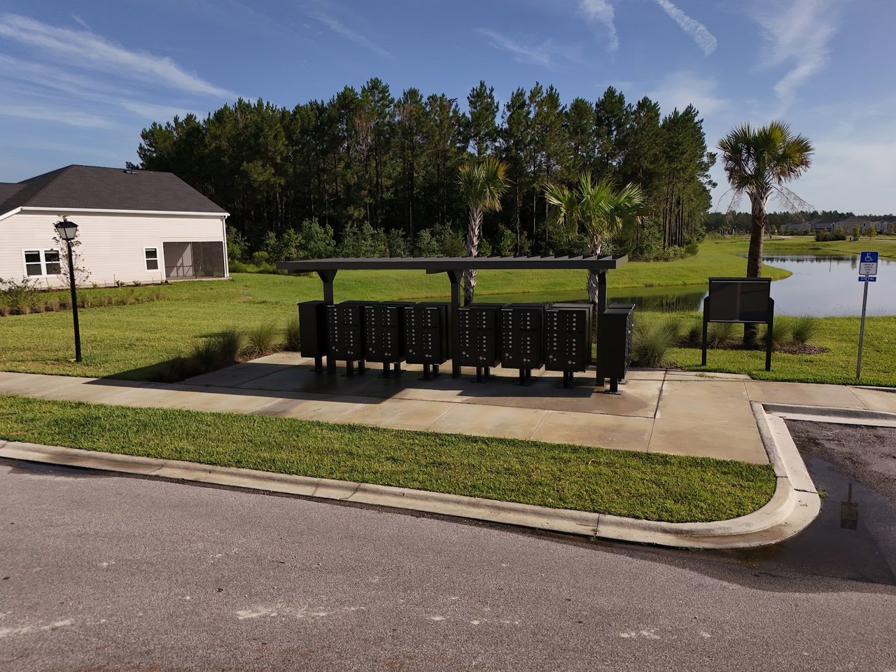 Community mailboxes beside a pond and palm trees in Silver Falls.