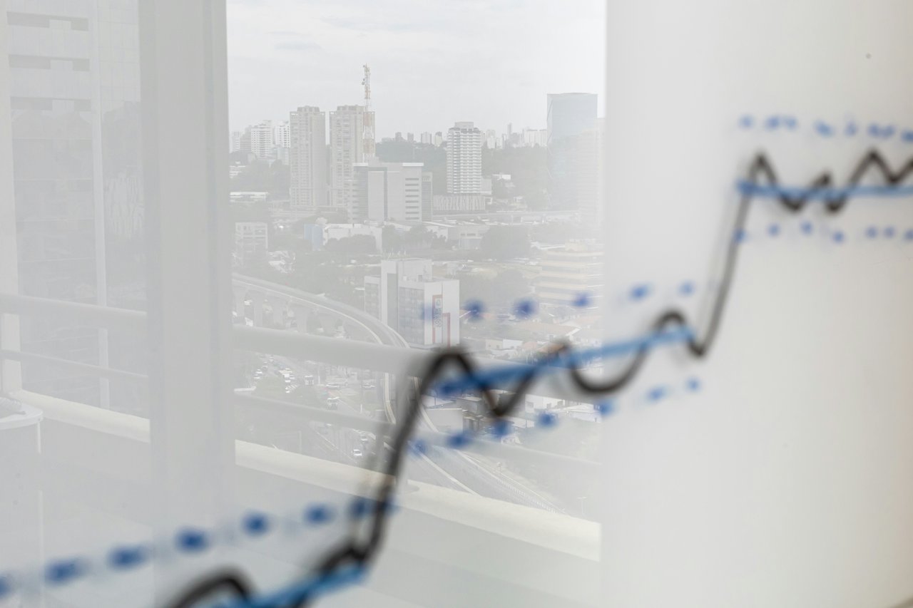 Rising market chart over a city skyline viewed through a window