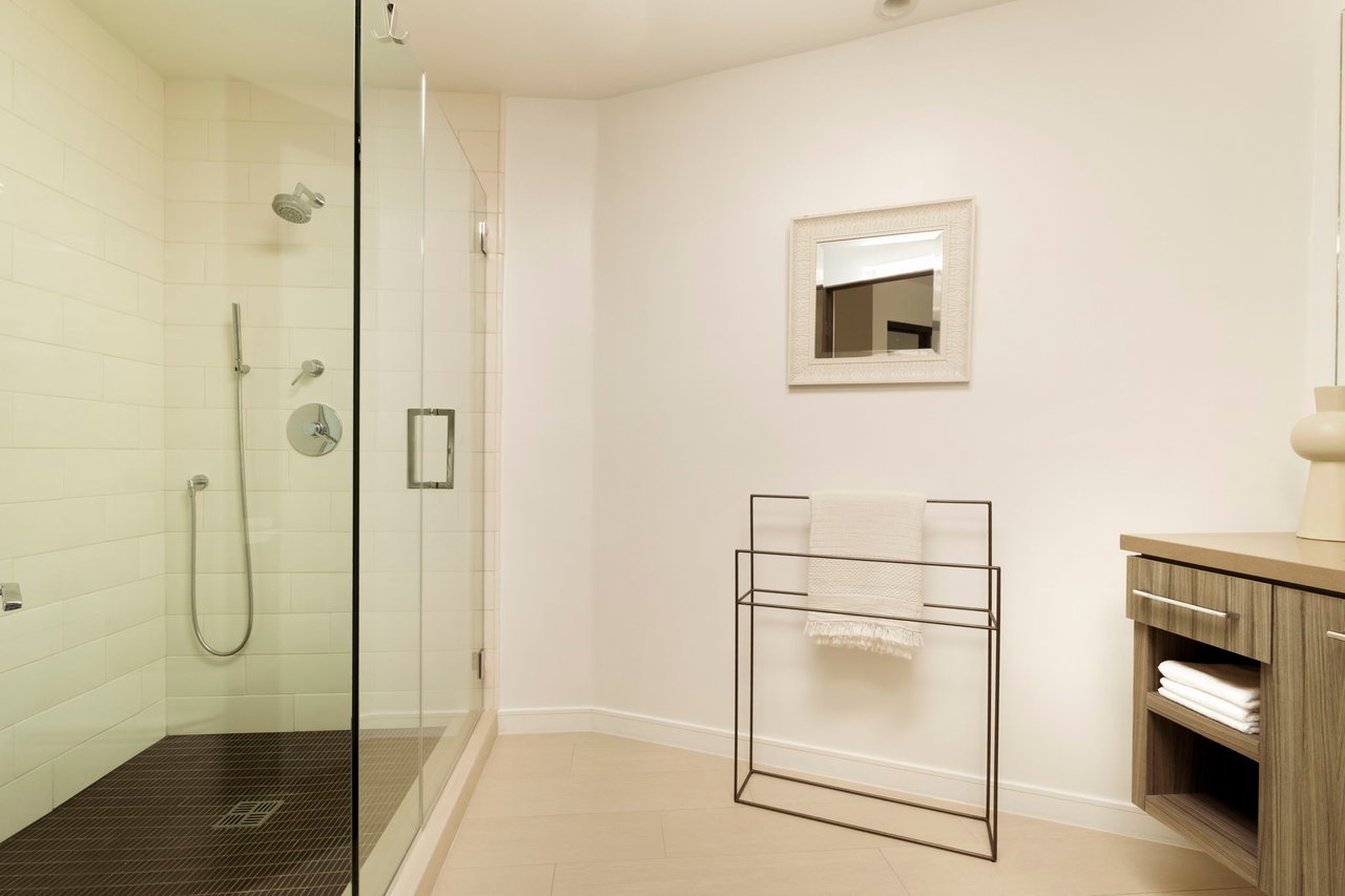 Modern bathroom with a glass-enclosed walk-in shower and wood vanity.