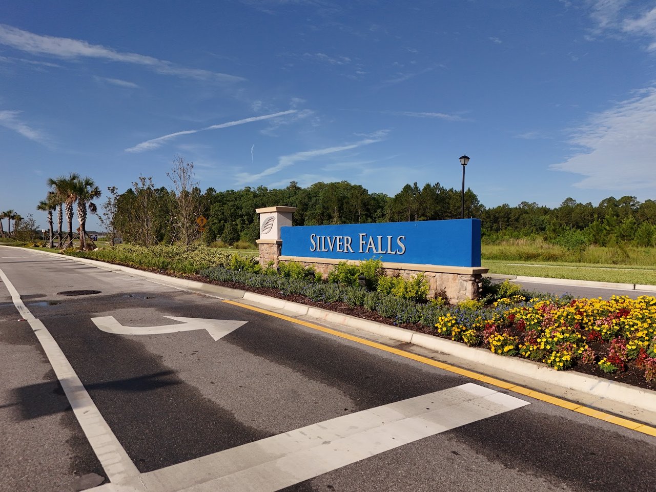 Silver Falls entrance sign beside a landscaped flower bed and roadway.
