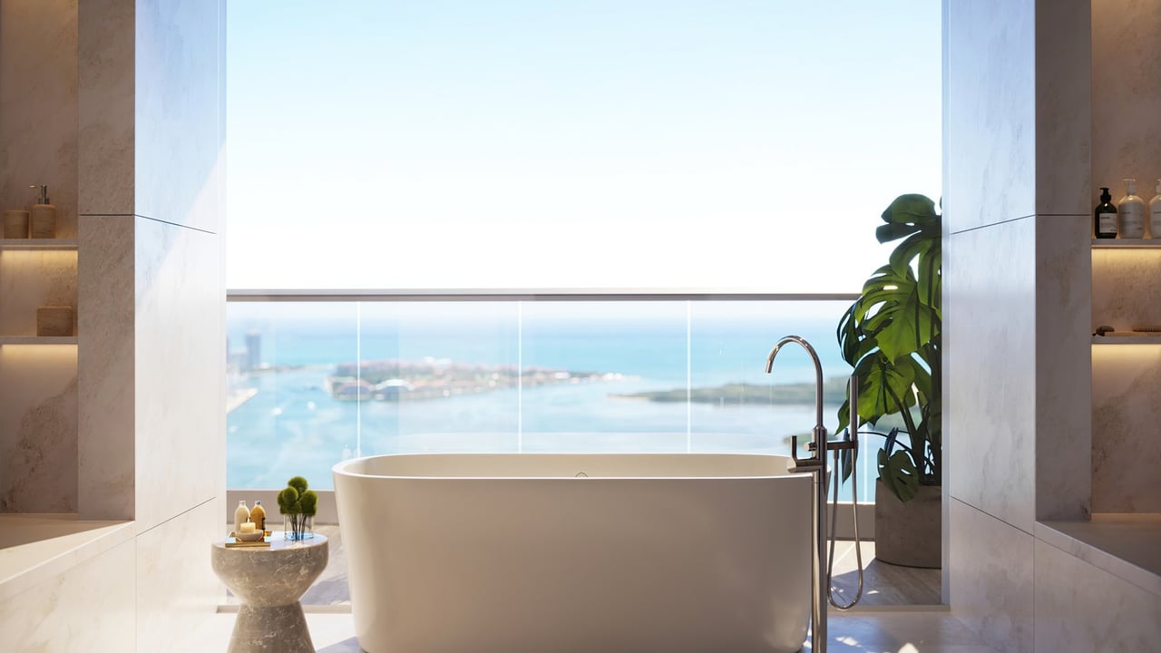 Marble bathroom with a freestanding tub and floor-to-ceiling water views.