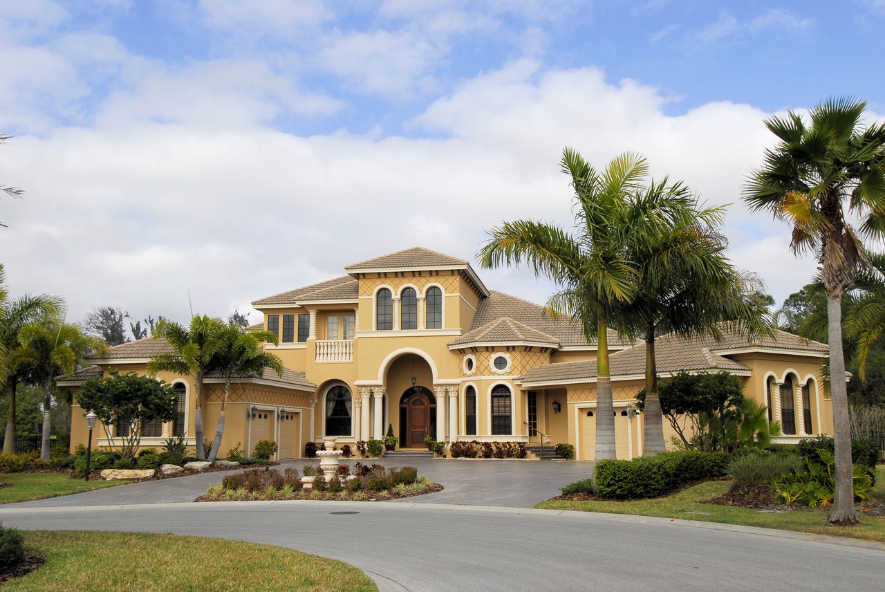 Mediterra’s Mediterranean-style building with arched windows, palm trees, and landscaped grounds.
