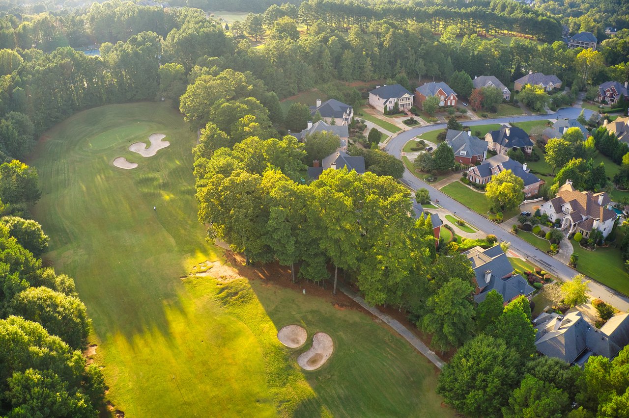 Aerial view of golf course and homes in a wooded community