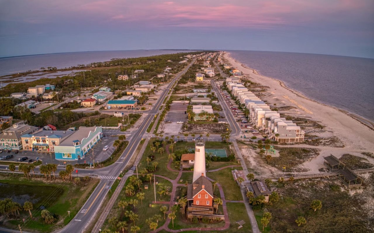 Aerial view of St. George Island, with its lighthouse, coastal homes, and beaches at dusk.