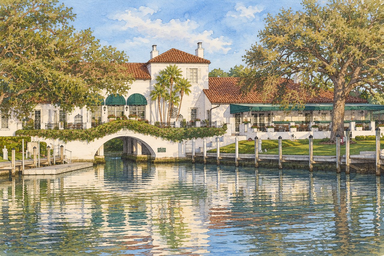 Waterfront Spanish-style building with green awnings, an arched passage, and a dock along the canal.