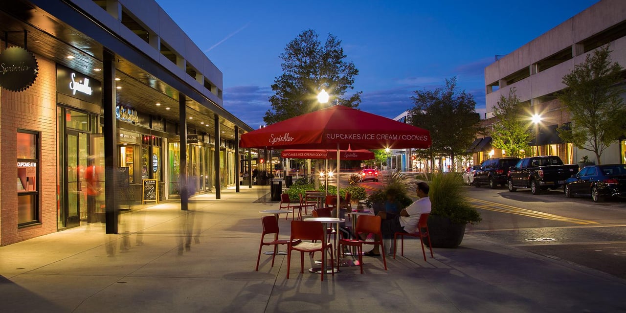 Hyde Park Village illuminated in the evening with shops and restaurants