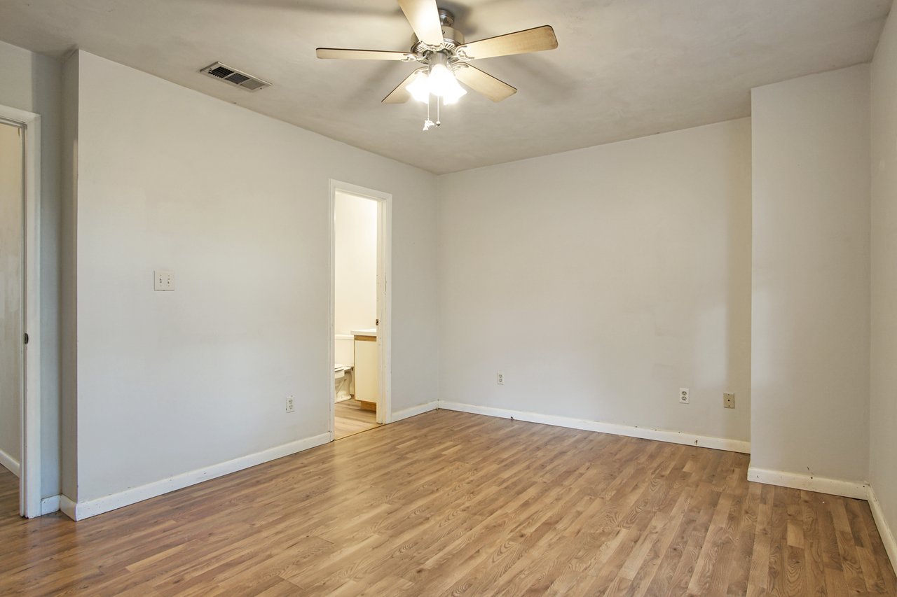 An empty room featuring hardwood floors and a ceiling fan, creating a spacious and airy atmosphere.An empty room featuring hardwood floors and a ceiling fan, creating a spacious and airy atmosphere.