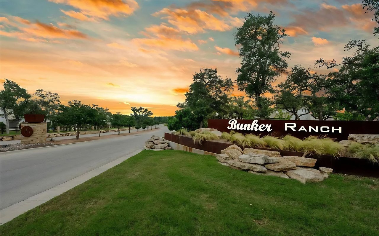 Bunker Ranch entrance sign beside a landscaped road at sunset.