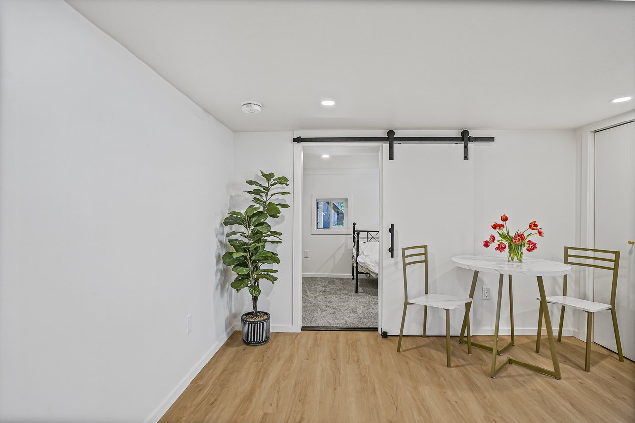Bright, multi-purpose room with wood flooring and white walls — ideal as a rentable suite, guest room, or home office in Victoria, BC.