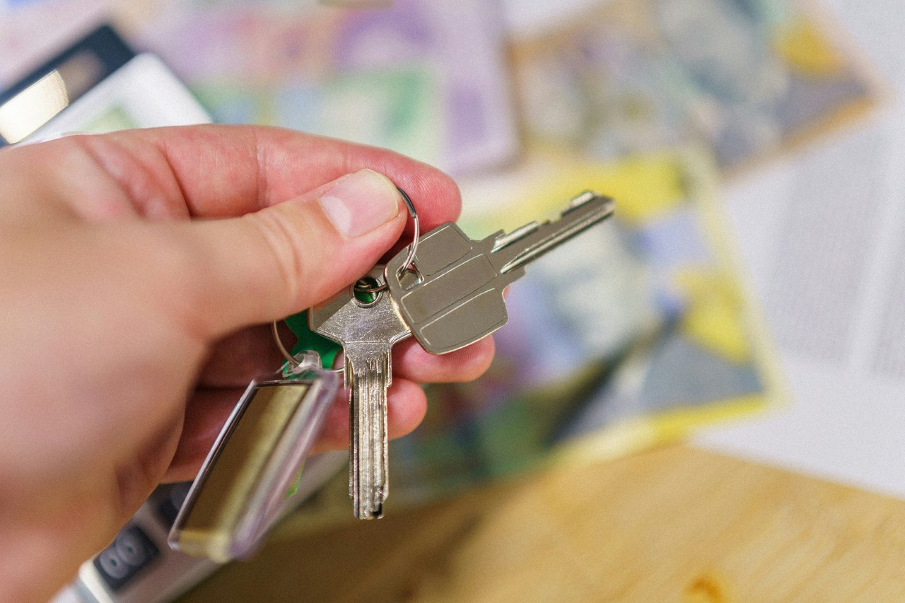 A hand holds a set of house keys.