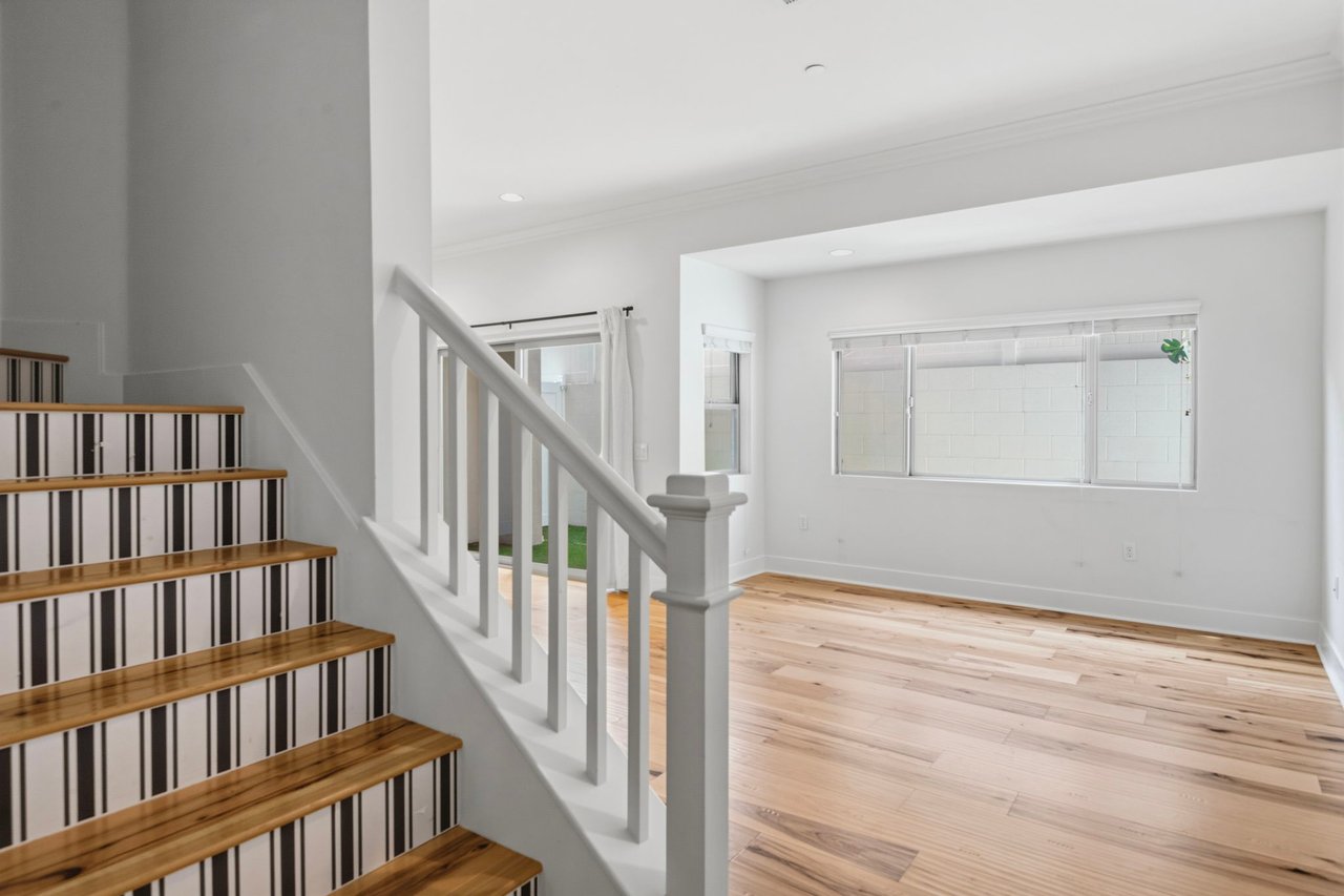 Staircase with hardwood treads, white risers, painted balusters, and natural light from landing window
