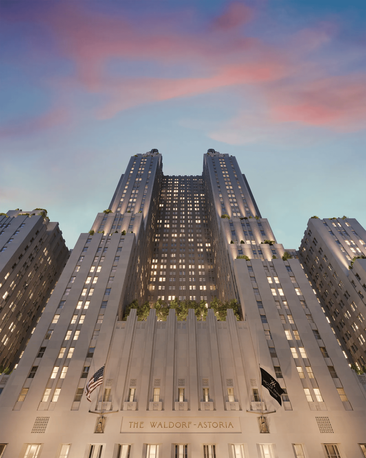 Waldorf Astoria building at dusk, viewed from below with its illuminated towers and entrance sign.