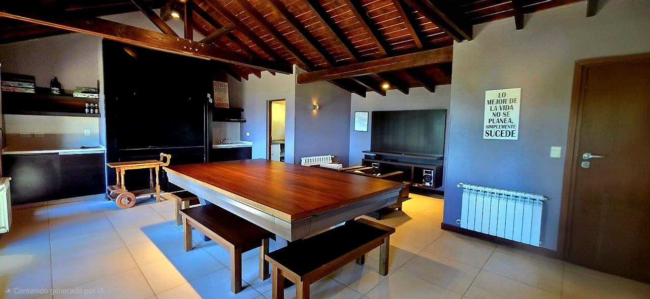 Game room with a large wooden pool table, benches, and an exposed timber ceiling.