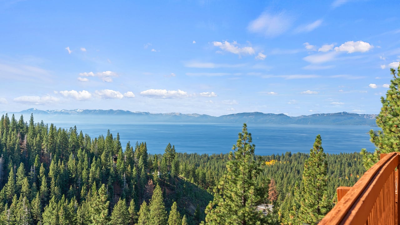 Lake Tahoe and the far-shore mountains beyond a pine forest, seen from the Ski Way neighborhood in Incline Village, Nevada