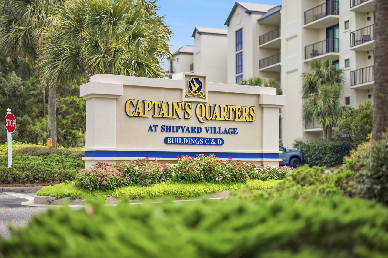 Captain's Quarters at Shipyard Village entrance sign in front of apartment buildings and landscaped grounds.