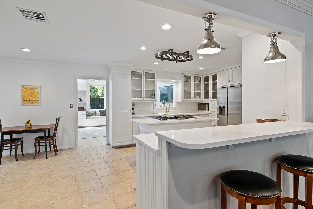 Kitchen with white cabinetry, tile flooring, and a dining nook, Tarrytown, Austin.