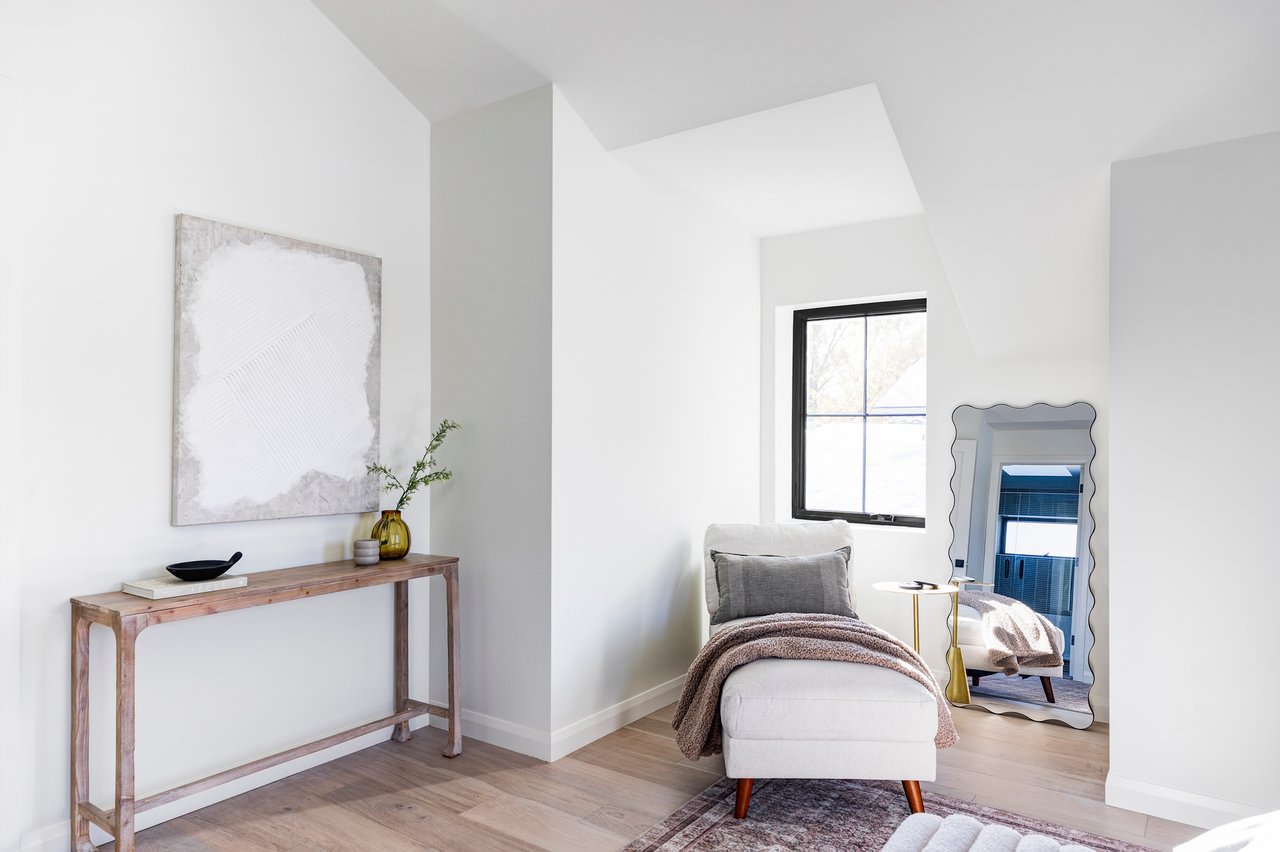 Corner of primary suite with wood console table and modern artwork