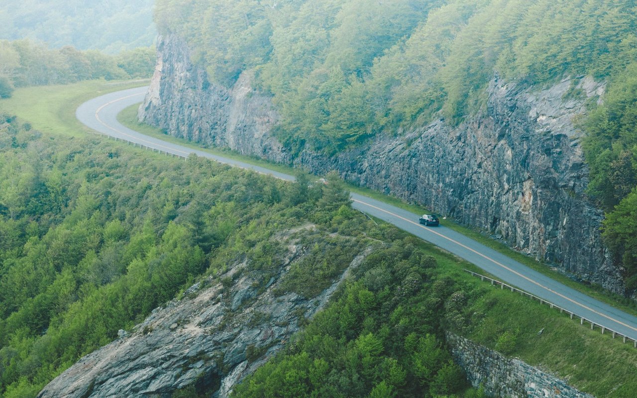 A photo of a car driving on a winding road in Jackson County North Carolina