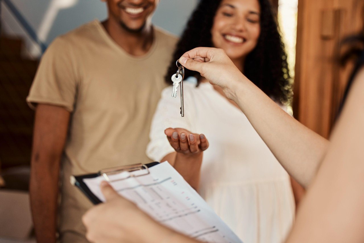 Homebuyers receiving the keys to their new home after completing the home buying process.