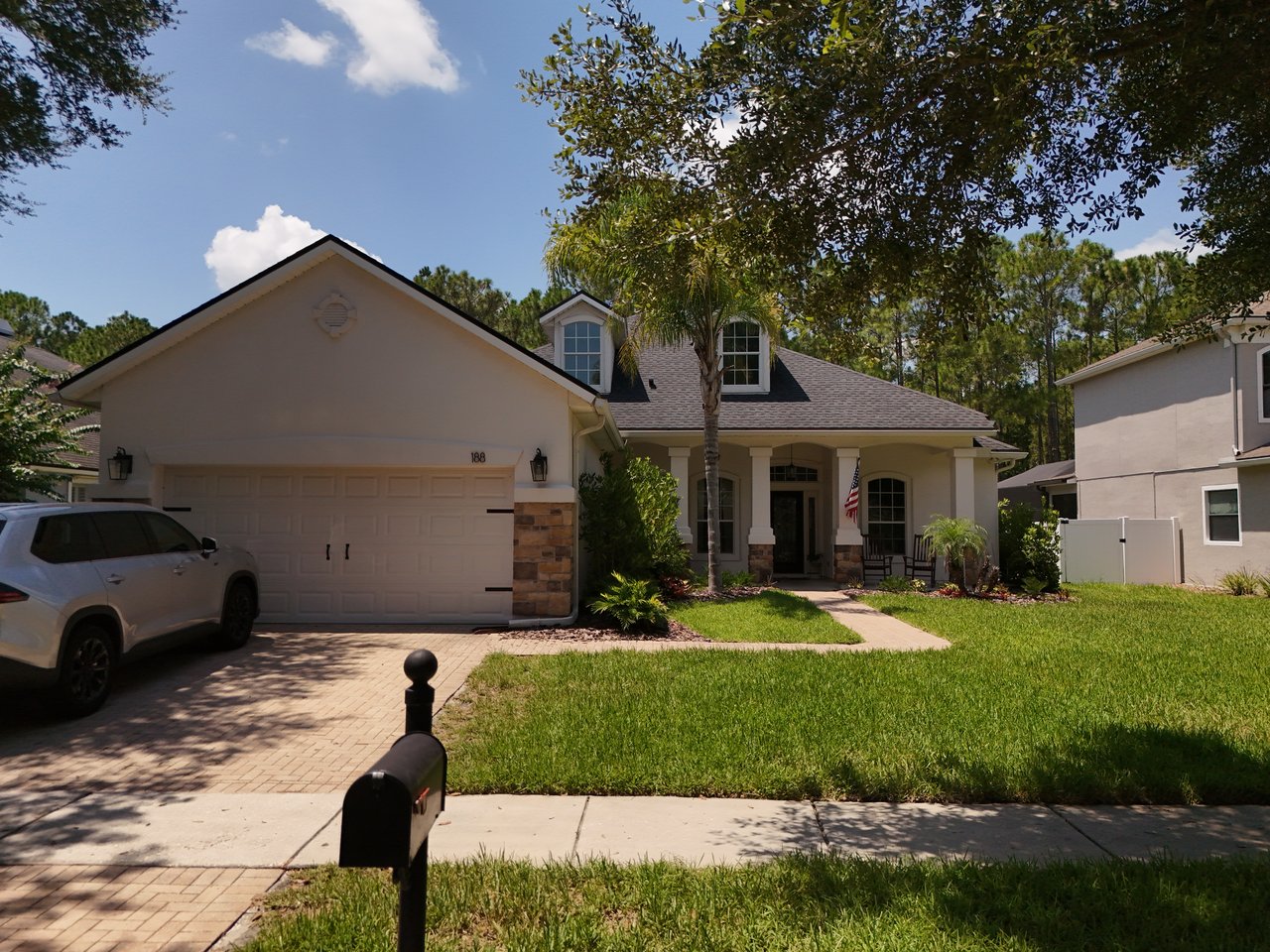 Two-story home with a two-car garage, covered entry, and landscaped front lawn.
