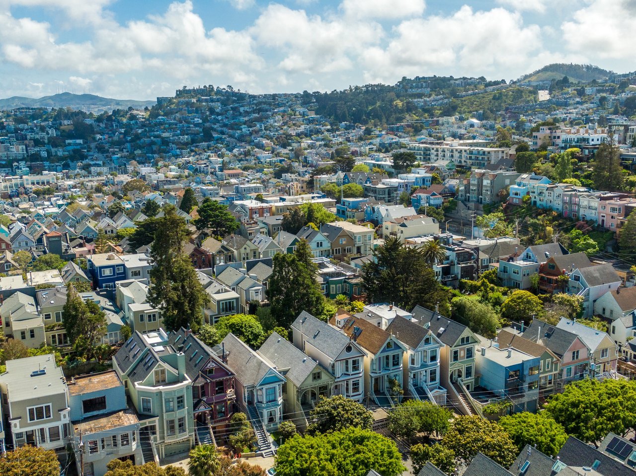 Homebuyer reviewing multiple offers with real estate agent in San Francisco, discussing offer terms and strategy for a competitive market