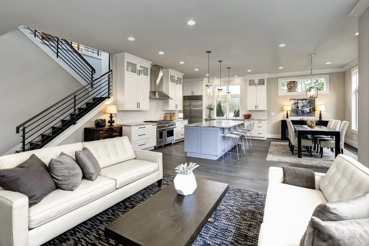 Open-plan living room, kitchen, and dining area with a large island and staircase.