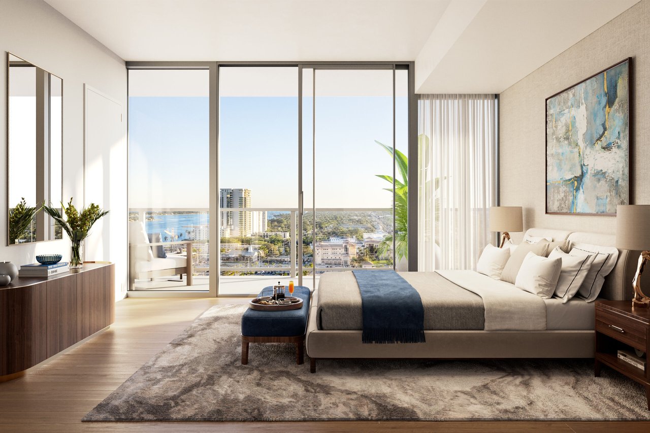 Furnished bedroom with floor-to-ceiling windows overlooking West Palm Beach and the water.