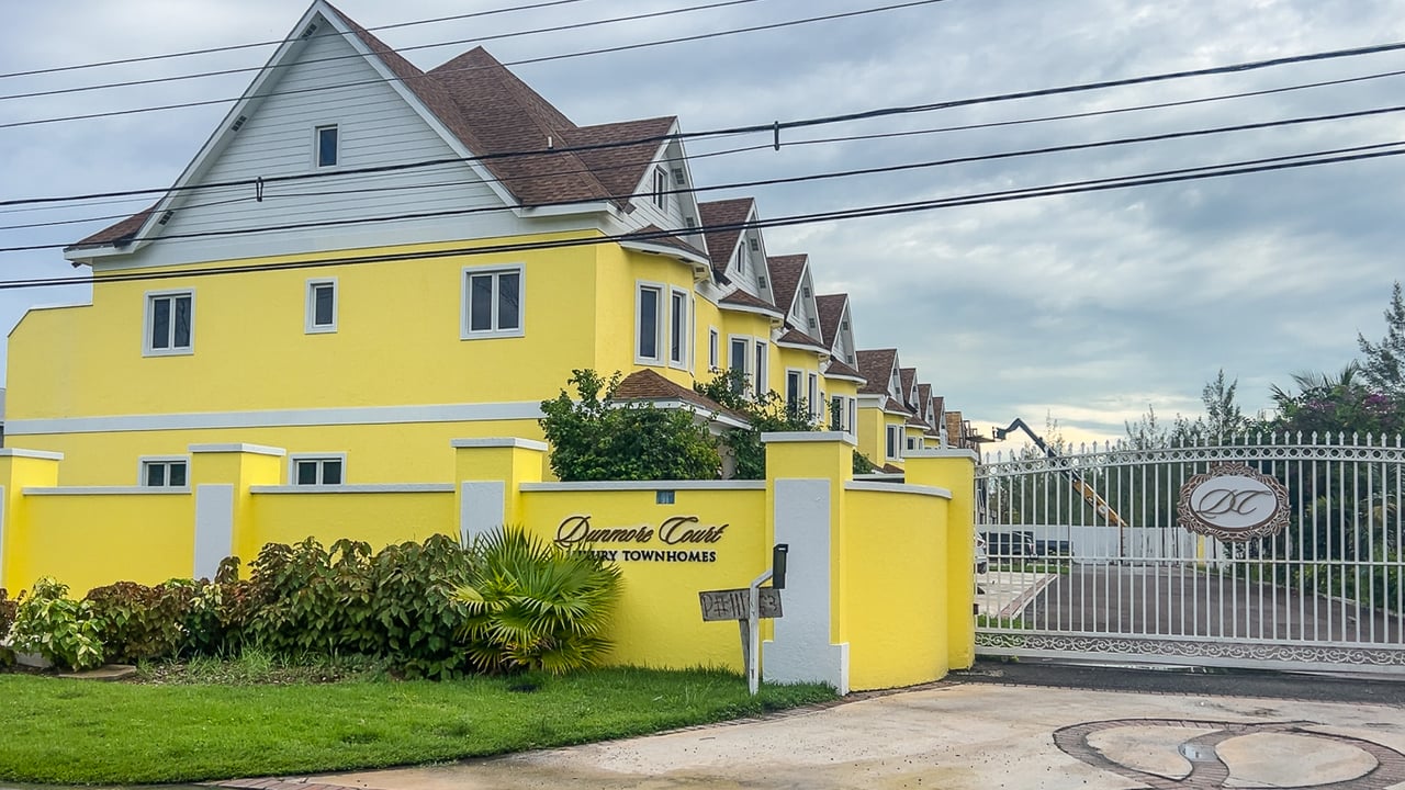 Dunmore Court luxury townhomes with yellow façades and a gated entrance.