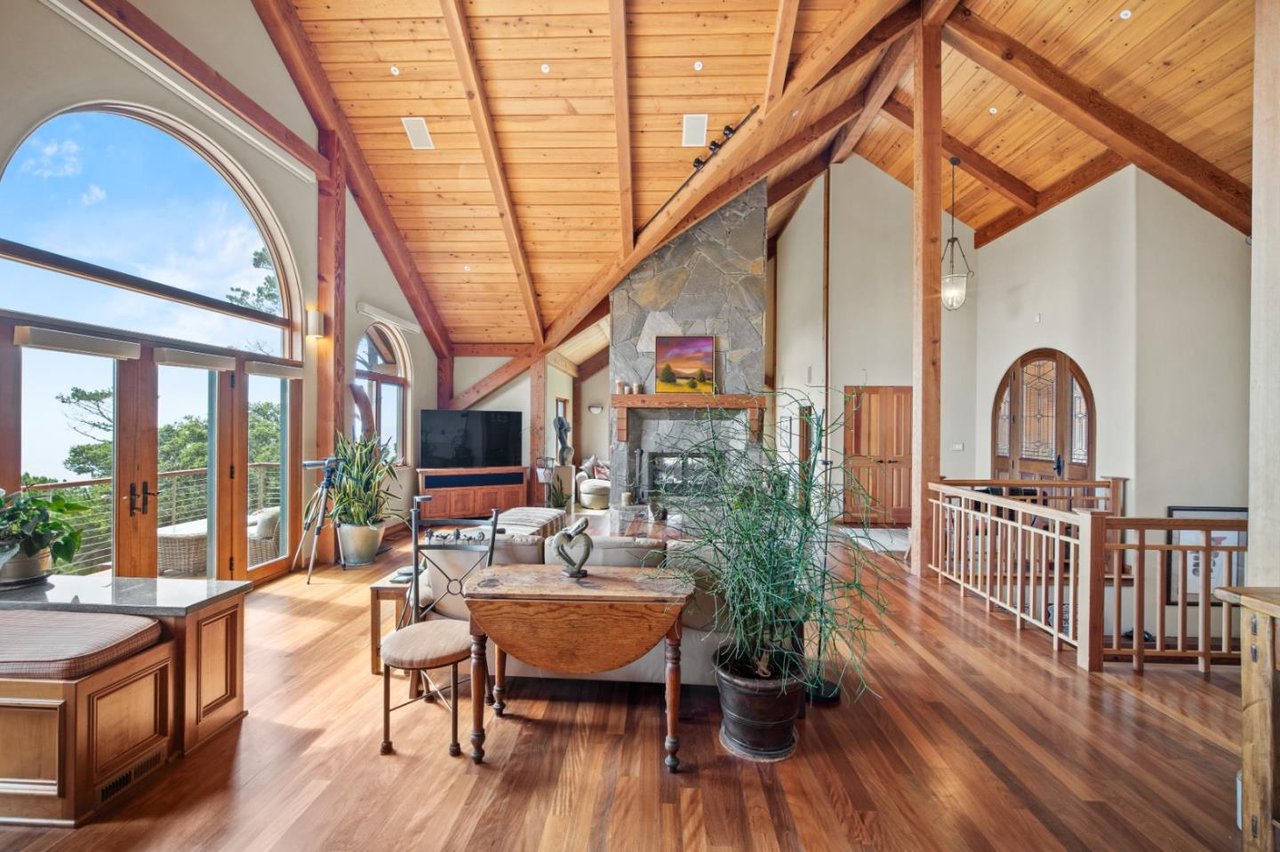 Living room with vaulted timber ceilings and ocean views in $5.5M Carmel Highlands home for sale