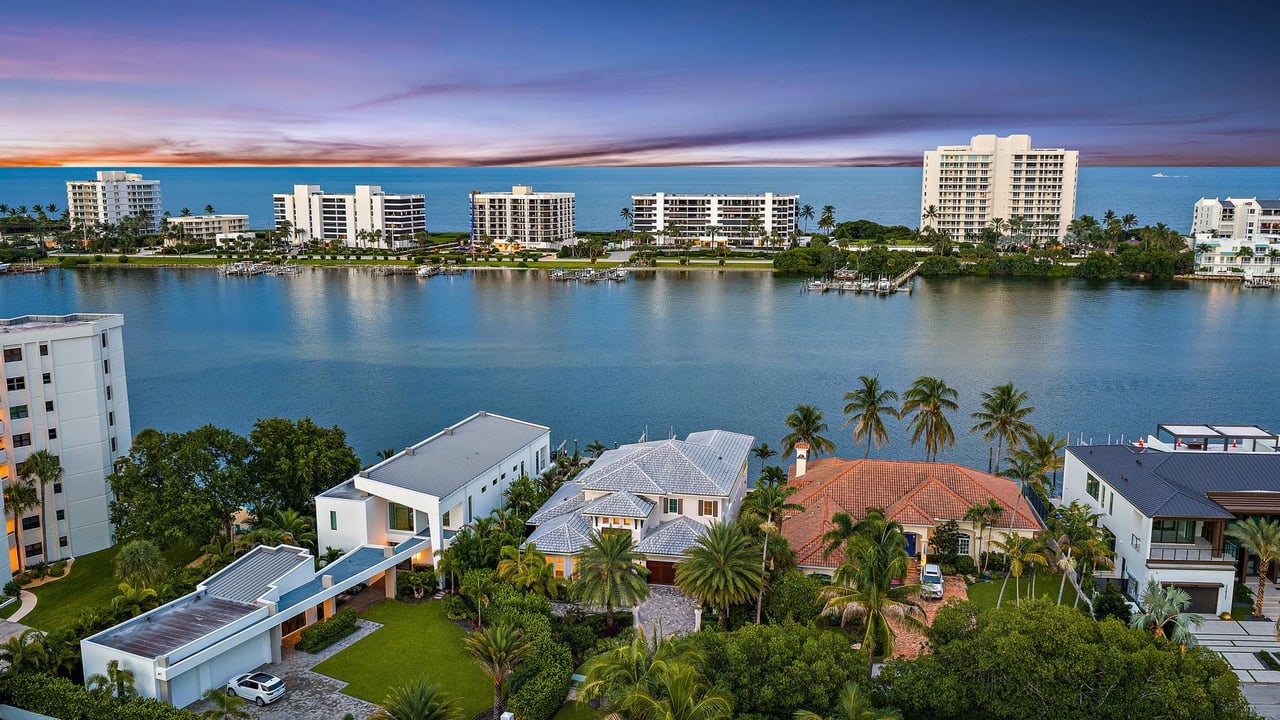 Private dock with a 24,000-pound boat lift on wide Intracoastal water behind a luxury waterfront home in Jupiter, Florida