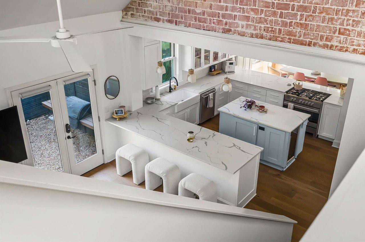 Two-story family room with brick accent wall, open to the kitchen, at 1500 Northwood Rd, Pemberton Heights, Austin. Renovation by McWalters Collaborative.