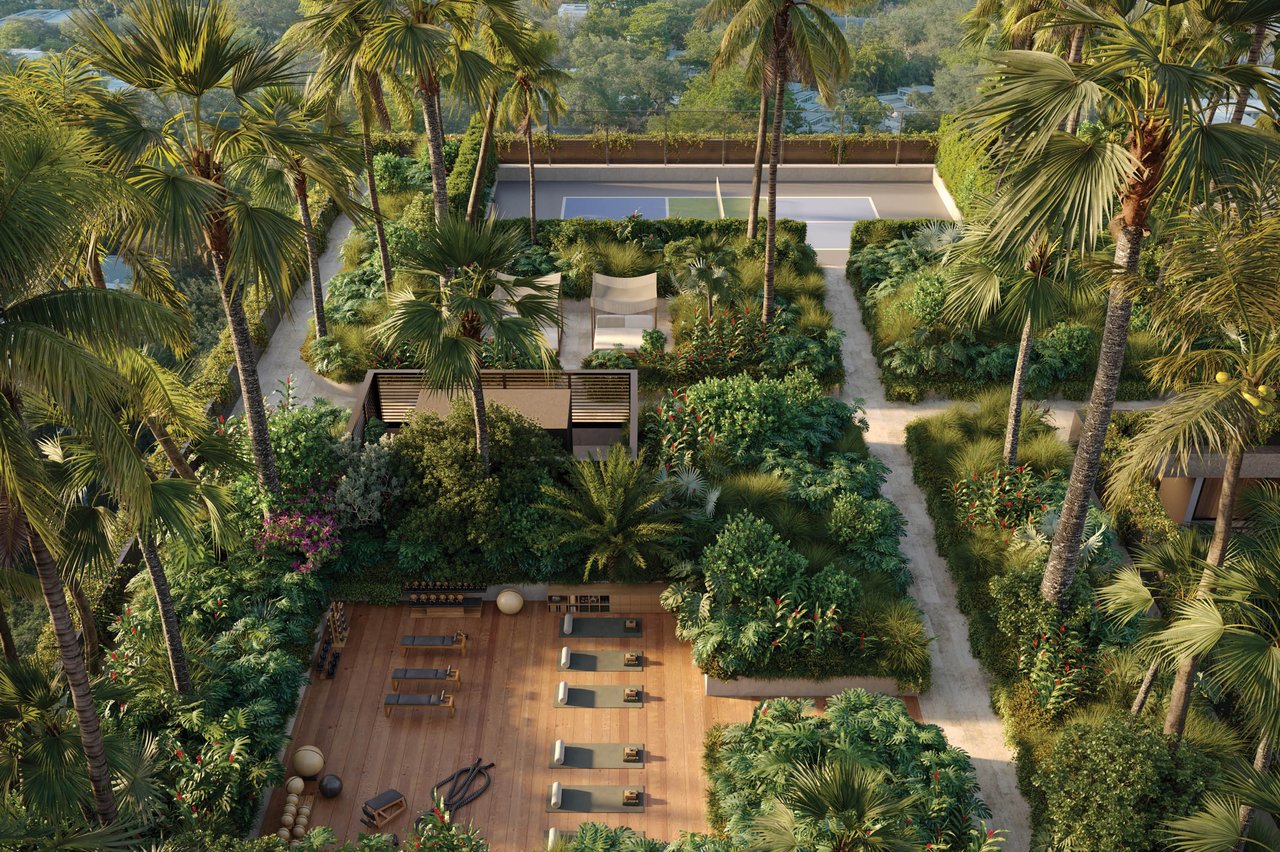 Landscaped amenity courtyard with a rectangular pool, tropical pathways, and a wooden deck with exercise mats.