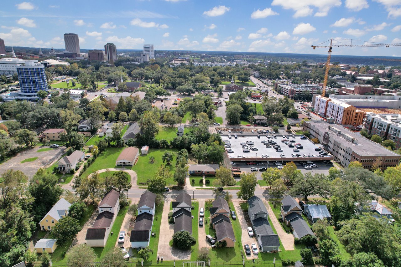 Aerial view of a neighborhood showcasing houses surrounded by lush green trees.