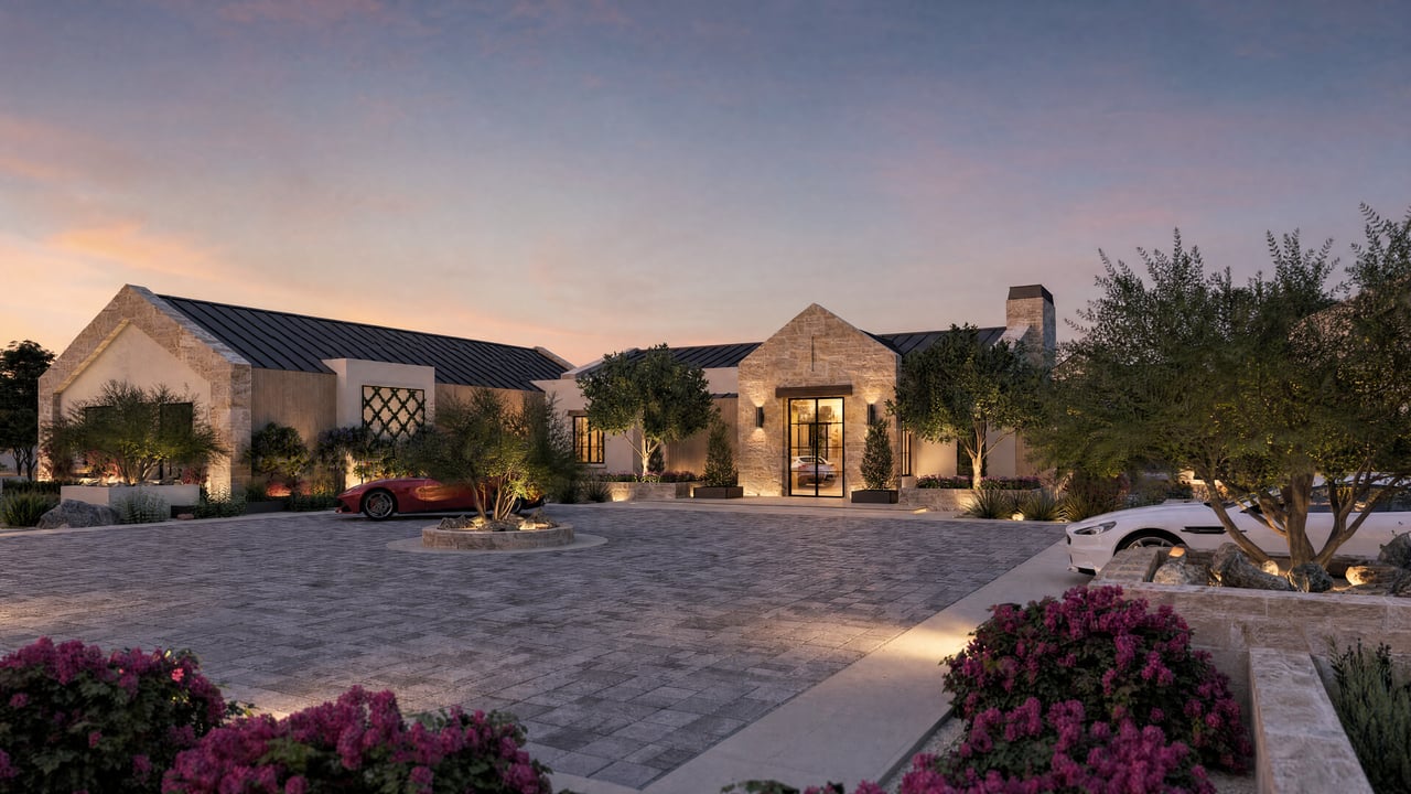 Luxury stone residence with dark metal roofs and a landscaped courtyard at dusk.