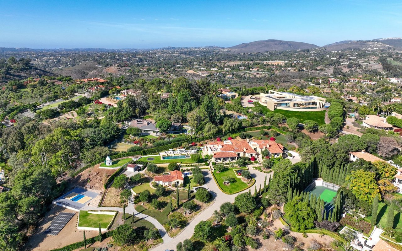 Aerial view of Rancho Santa Fe homes and landscaped estates among rolling hills.