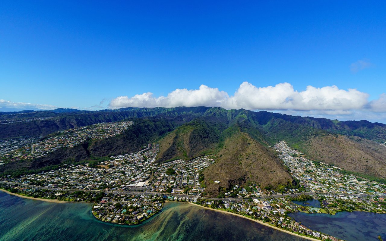 Aerial view of Kalama Valley neighborhoods between green mountains and the coast.
