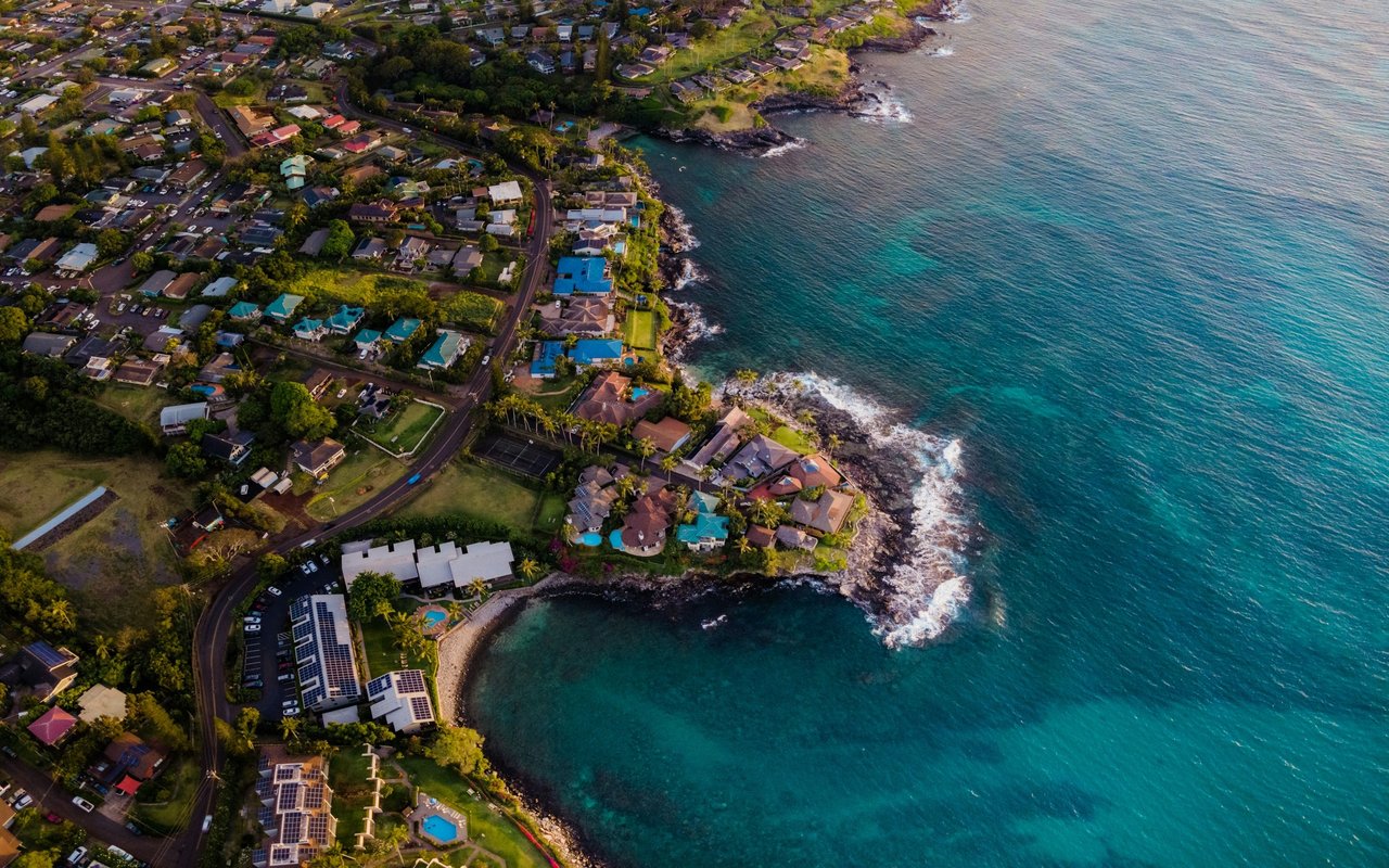 Anasco coastal neighborhood with homes along a rocky shoreline and turquoise inlet.